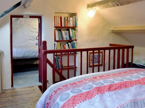 1 dormitorio con 1 cama y estantería con libros en Bryn Rhos Goch, en Dolwyddelan