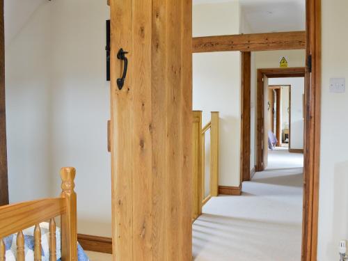 a hallway with a wooden door in a house at The Granary in Tytherton Lucas