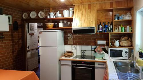 La cuisine est équipée d'un réfrigérateur blanc et d'un évier. dans l'établissement Home@Chiny, à Chiny