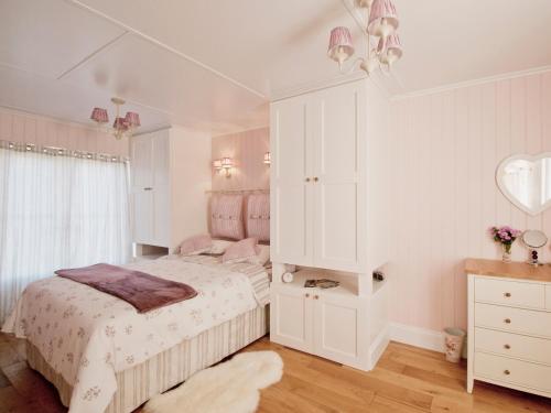 a bedroom with a bed and a dresser and a mirror at Dunultach Cottage in Ronachan