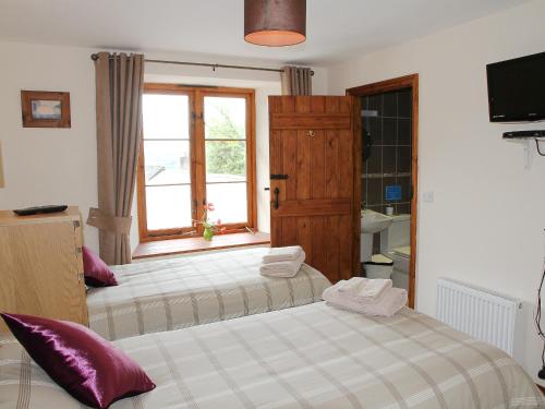 1 dormitorio con 2 camas y ventana en The Coach House - Exg, en Upton