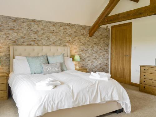 a bedroom with a large white bed with two towels on it at Llofft Storws in Valley