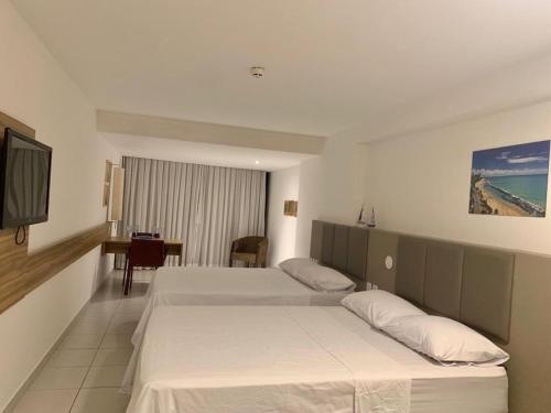 Habitación de hotel con 2 camas y TV en Beach Class Executive, en Recife