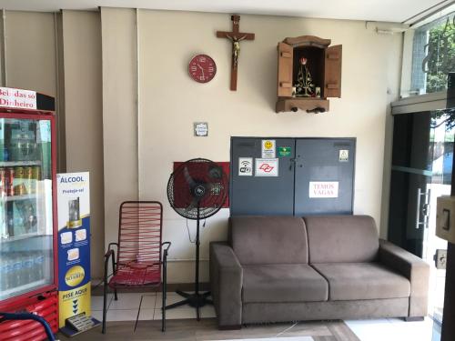 a gas station with a couch and a clock on the wall at Pousada Soares in Aparecida