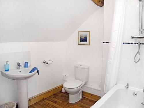 a white bathroom with a toilet and a sink at Pasture Barn in Lockton