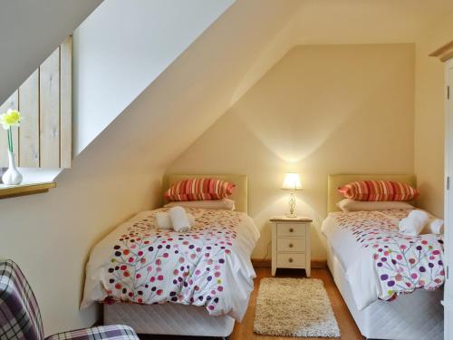 two twin beds in a attic bedroom with stairs at Bramble Cottage in Newland