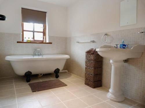 a bathroom with a bath tub and a sink at The Stables in Hornsea