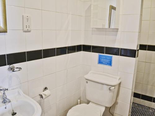 a bathroom with a toilet and a sink at Apple Cottage - 27442 in Sedlescombe