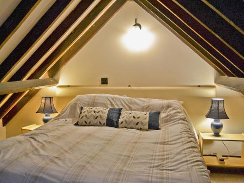 a bedroom with a large bed in a attic at Apple Cottage - 27442 in Sedlescombe