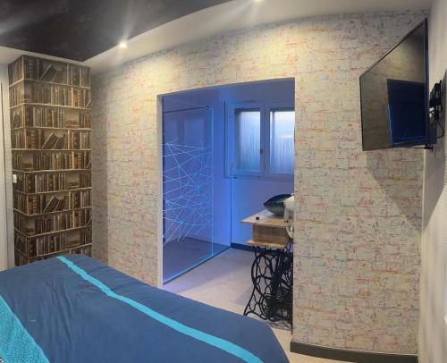 um quarto com uma porta azul e uma parede de tijolos em Spa 166 jets, Bord de mer by Carl-Emilie em Épinal