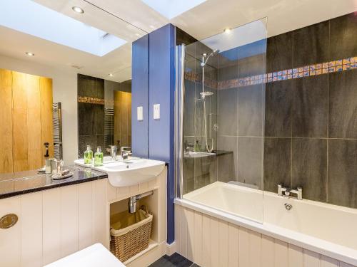 a bathroom with a sink and a bath tub at The Hayloft in Blitterlees