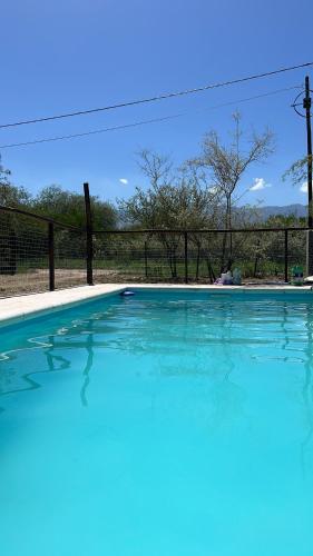 uma grande piscina com água azul em frente a uma cerca em Casa Grande Reservas por privado em San Javier