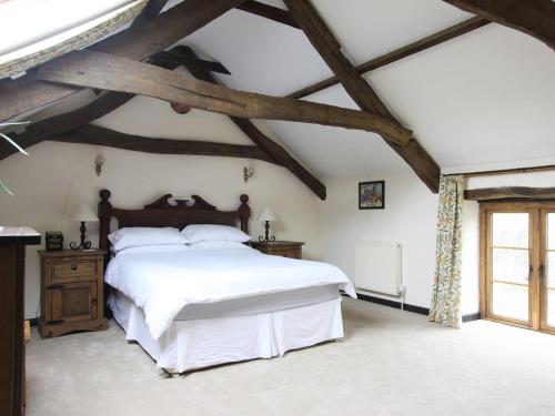 um quarto com uma cama grande e lençóis brancos em Passion Flower Cottage - E1468 em Stowford