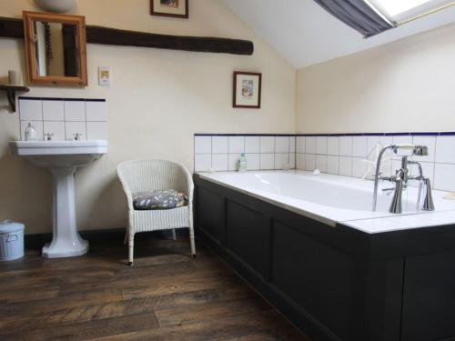 uma casa de banho com uma banheira grande e um lavatório em Passion Flower Cottage - E1468 em Stowford