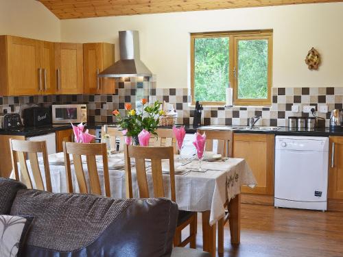 a kitchen with a table and chairs with flowers on it at Oakview in Llandrindod Wells