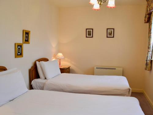 duas camas num quarto com duas camas brancas em Perriwinkle-mgh em Akeld