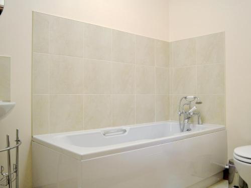 El baño incluye bañera blanca y aseo. en The Parlour - Op4, en Carmarthen