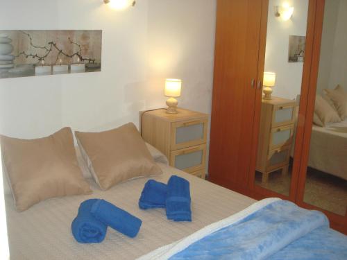 a bedroom with a bed with blue towels on it at Apartamento Cotillo in Cotillo