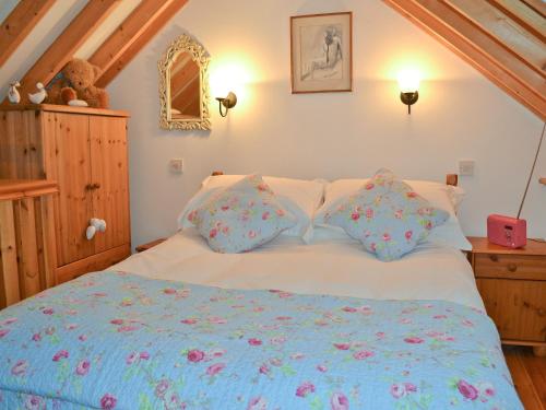 a bedroom with a white bed with flowers on it at Angel Barn in Farden