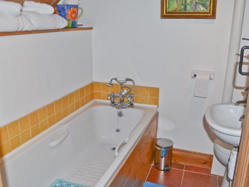 a bathroom with a bath tub and a sink at Angel Barn in Farden