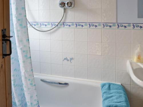 een badkamer met een douche en een blauwe handdoek bij Weach Barton Granary in Bideford