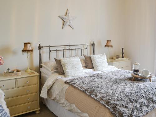 um quarto com uma cama e duas mesas de cabeceira e dois candeeiros em Ferncliffe Cottage em Snitter