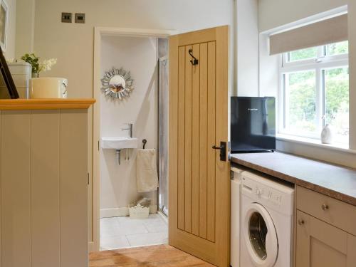 a kitchen with a washing machine and a window at Ferncliffe Cottage in Snitter