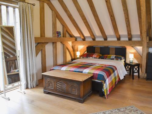 a bedroom with a bed and a wooden floor at Little Timbers in Woodmancote