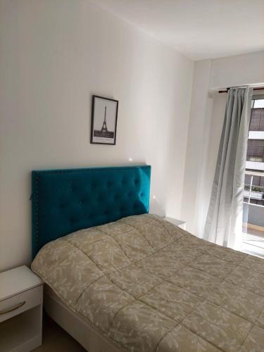 1 dormitorio con 1 cama con cabecero azul y ventana en Wonderful Las Cañitas en Buenos Aires