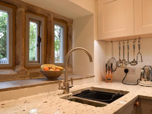 uma cozinha com um lavatório e uma taça de fruta em Prospect Cottage em Kettlewell
