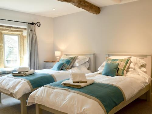 ケトルウェルにあるProspect Cottageのベッド2台が隣同士に設置された部屋です。