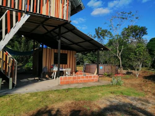 Un pabellón con un hombre sentado en una mesa en un patio en FINCA AGROTURISTICA VILLA MANE, en San José del Guaviare