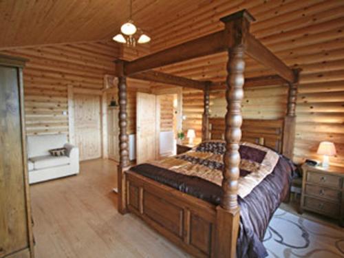 a bedroom with a bed in a log cabin at Bracken Log Cabin - S4468 in Glenfarg