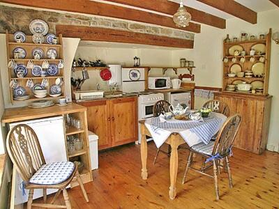 cocina con mesa y sillas en una habitación en Bowjy Coth, en Lower Boscaswell