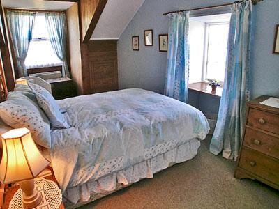 Un dormitorio con una cama grande y una ventana en Bowjy Coth, en Lower Boscaswell