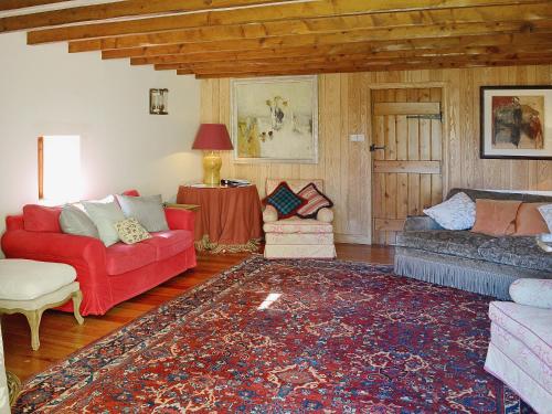a living room with two couches and a rug at Arkland Mill in Corsock