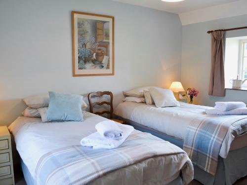 - une chambre avec 2 lits et des serviettes dans l'établissement Cowbeech Farm Cottage, à Herstmonceux