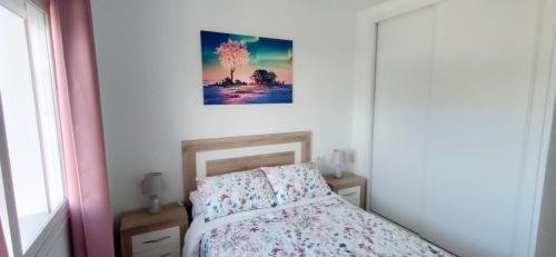 een slaapkamer met een bed en een foto aan de muur bij Jardines del Lago de Costa Ballena in Chipiona
