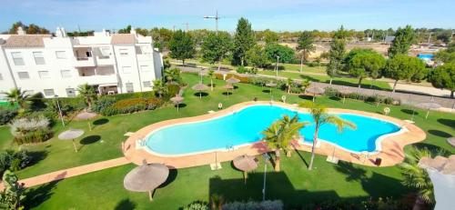 een uitzicht over een zwembad in een resort bij Jardines del Lago de Costa Ballena in Chipiona