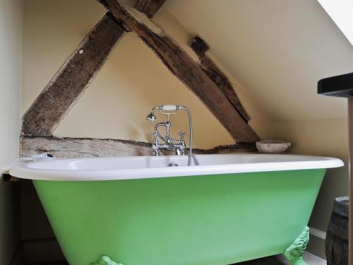 Frodesley的住宿－貝基亞鄉村別墅，浴室内设有带水龙头的绿色浴缸