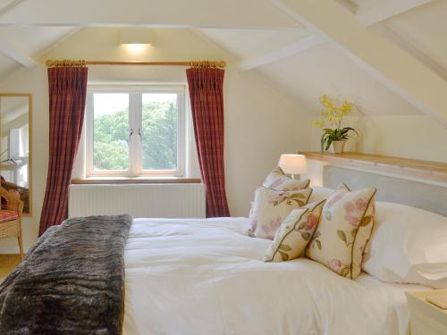 a white bed in a room with a window at Fishermans Nook in Holne