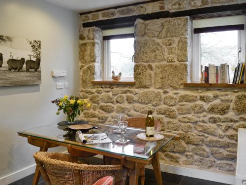 a stone wall with a table and a bottle of wine at Fishermans Nook in Holne