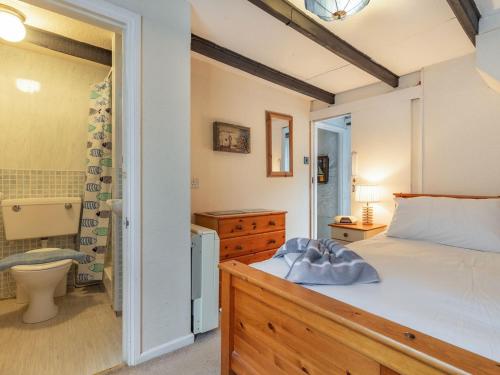 a bedroom with a bed and a bathroom at Talland House in Polperro