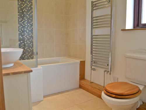 Swallows Retreat في هارتلاند: حمام مع مرحاض ومغسلة وحوض استحمام