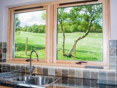 a kitchen window with a view of a field at Treetops in Newtonmore