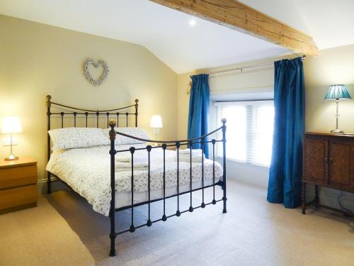 una camera da letto con un letto con tende blu e una finestra di Hallgarth House a Pickering