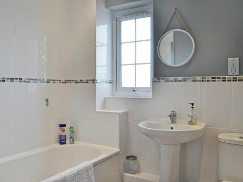 a white bathroom with a sink and a mirror at Seaview in Garlieston