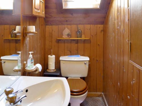 a wooden bathroom with a toilet and a sink at Dalvanie Mill - S4241 in Tulchan