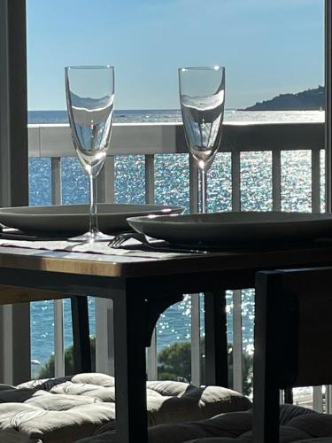 une table avec deux verres à vin sur un balcon dans l'établissement Vacances paradisiaques, Plage Cannes boccacabana, studio, à Cannes