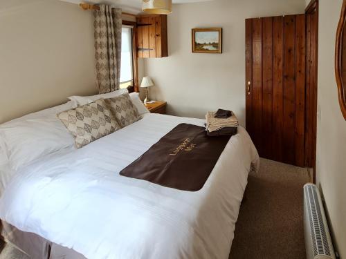 a bedroom with a bed with a brown blanket on it at Herons View - 28279 in Brundall